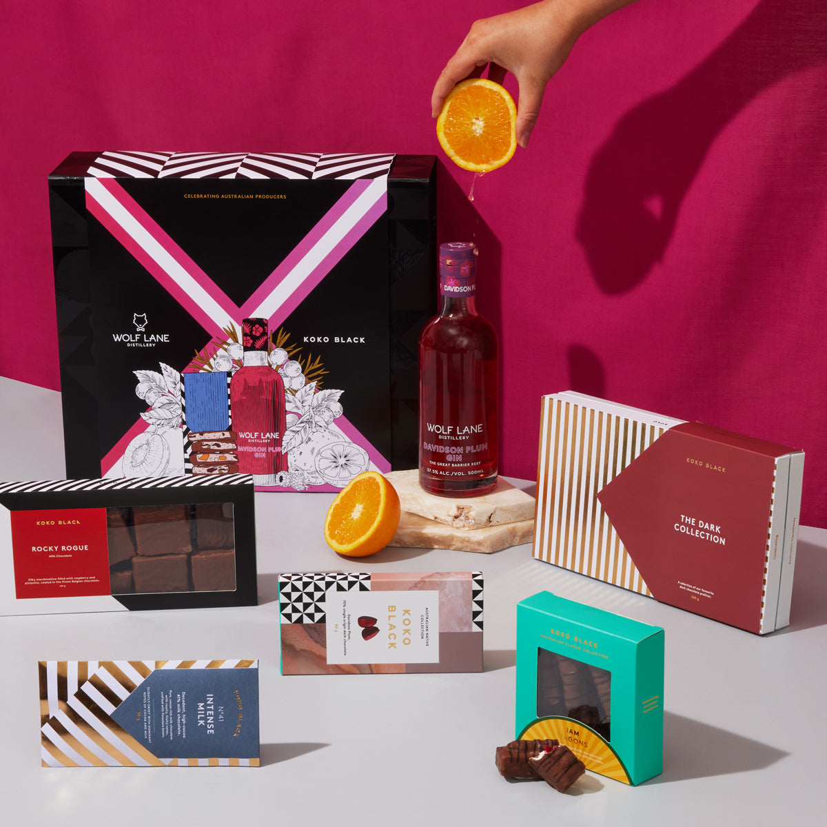 Gin bottle surrounded by milk and dark packaged chocolates
